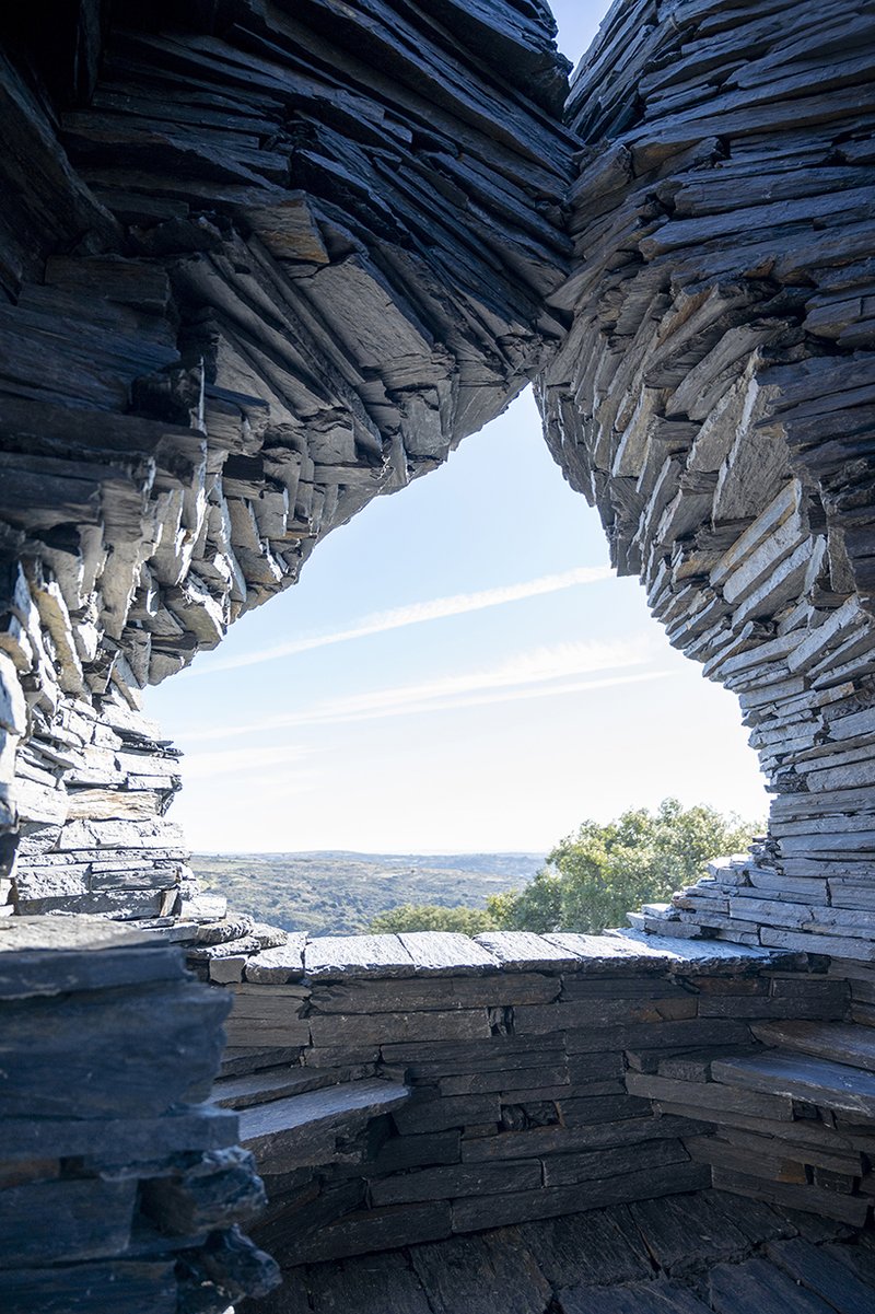 atelier yokyok sculpts sphere land installation out of black schist and granite in portugal